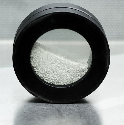 photography of a white granulate powder inside the cell of the granudrum instrument made by granutools